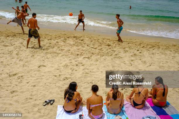 Girls watch as a group of boys play with a beach volleyball on the Oshri Beach on May 24, 2023 in Tel Aviv, Israel. Despite the recent IDF operation...