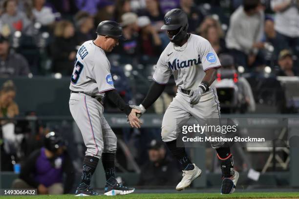 Jonathan Davis of the Miami Marlins is congratulated by Jody Reed as he circles the bases after hitting a solo home run against the Colorado Rockies...