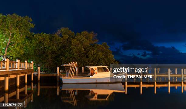 islamorada, florida keys - altes kleines boot, das nachts am pier angedockt ist - islamorada stock-fotos und bilder