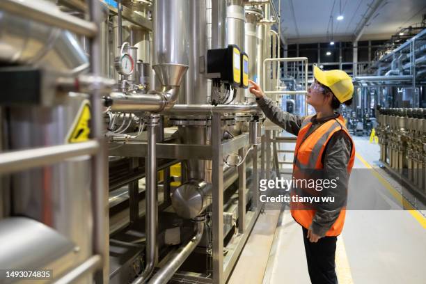 an asian female technician is inspecting equipment in an industrial factory - continuing development stock pictures, royalty-free photos & images