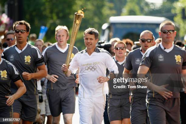 Frederik, Crown Prince of Denmark, carrries the Olympic Torch through Central London on July 26, 2012 in London, England.The Olympic flame is making...