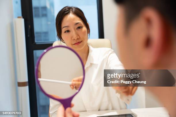 an asian female beauty consultant / aesthetic doctor is having a consultation session with an asian male client. - consultation lake bildbanksfoton och bilder