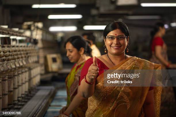 managerin zeigt daumen hoch-zeichen in der textilindustrie - ok werk stock-fotos und bilder
