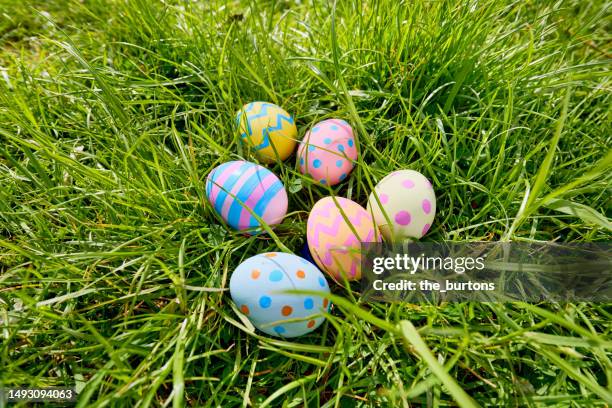 high angle view of colorful easter eggs on a meadow - easter religious stock pictures, royalty-free photos & images