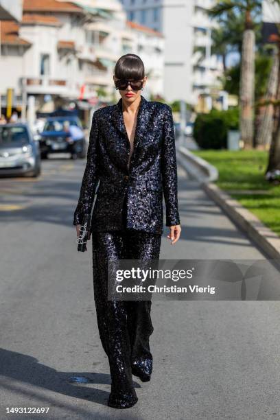 Katya Tolstova wears sequined black Philipp Plein suit, bag, sunglasses during the 76th Cannes film festival on May 24, 2023 in Cannes, France.