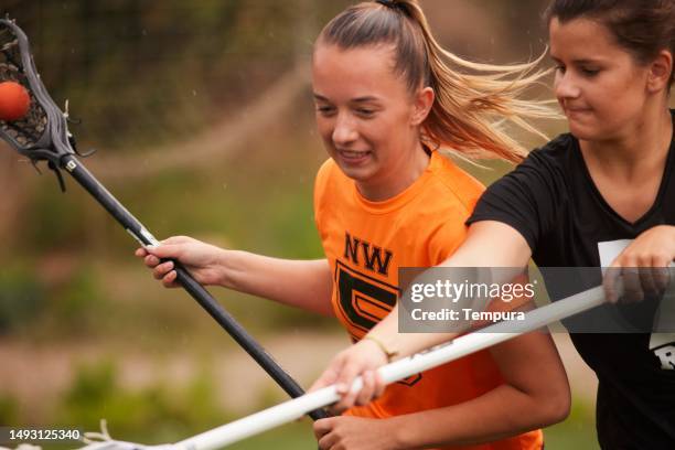 intense moment as lacrosse defender steps up, impeding rival's progress - fault sports stock pictures, royalty-free photos & images