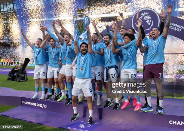 Manchester City captain Ilkay Gundogan lifts the Premier League trophy in front of team mates after the Premier League match between Manchester City...