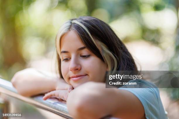 adolescente apoyada en una cerca en un parque natural, disfrutando sola al aire libre - croatia girls fotografías e imágenes de stock