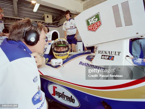 Patrick Head, Engineering Director of Williams Grand Prix Engineering talks to driver Ayrton Senna from Brazil in the cockpit of the Rothmans...