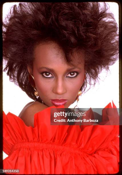 Portrait of Somali-born American fashion model Iman, dressed in red ruffled, strapless top, as she poses against a white background, New York, New...