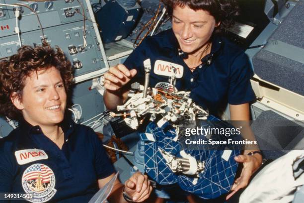 Astronauts Kathryn D. Sullivan and Sally Ride in the interior of the Challenger space shuttle during the STS-41-G mission, October 1984. They are...