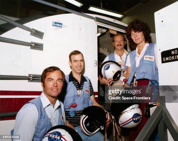 The crew of NASA's STS-7 space mission on the steps of the Shuttle Mission Simulator during training at the Johnson Space Center in Houston, Texas,...