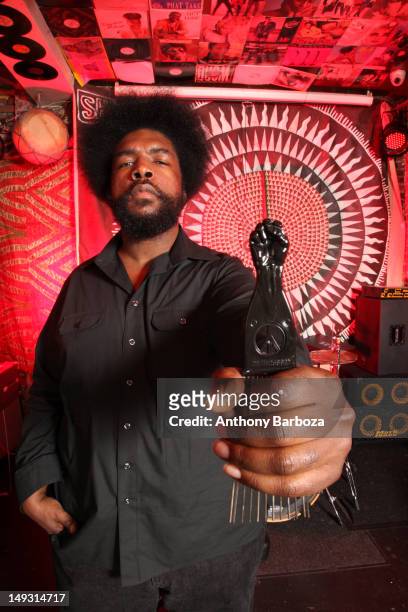 Portrait of American musician and producer Questlove , from the band The Roots, as he holds an afro pick decorated with a peace symbol and Black...