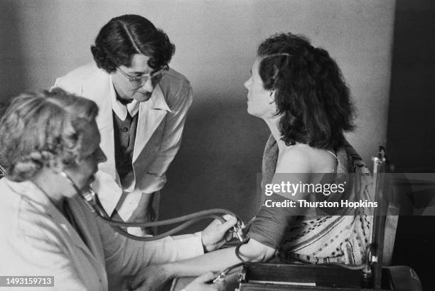 Female patient has her blood pressure checked by two nurses, October 1954. Original Publication: Picture Post - 7333 - You And Your Health - unpub....
