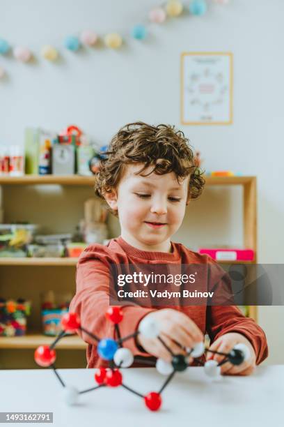 portrait of prescooler student researching molecular model toy in kindergarten - one boy stock pictures, royalty-free photos & images