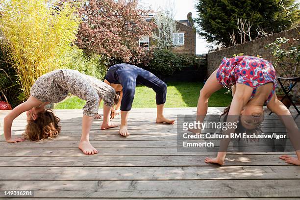 girls practicing yoga in backyard - bending over backwards stockfoto's en -beelden