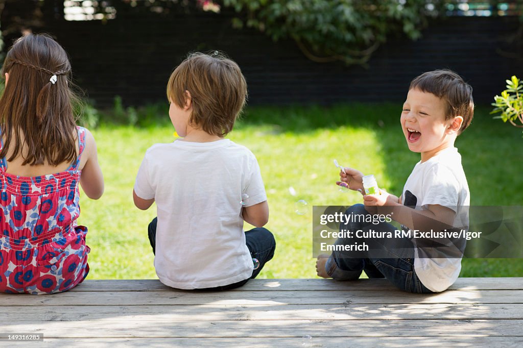 Children sitting together in backyard