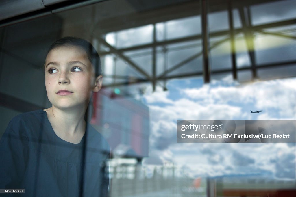 Girl watching airplane fly away