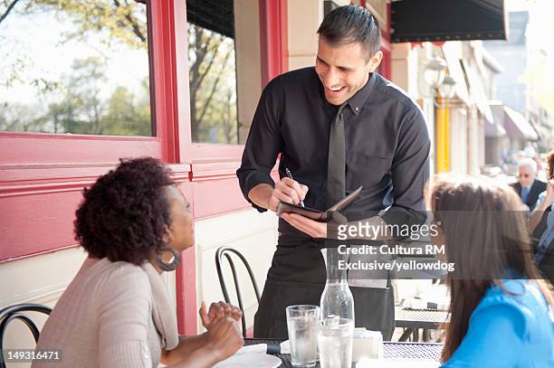 server taking orders at sidewalk cafe - serveur restaurant stock pictures, royalty-free photos & images