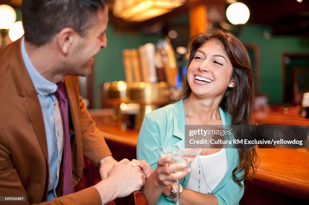 Smiling couple talking at bar