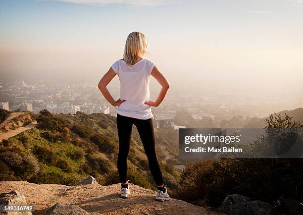 woman overlooking view from hilltop - woman hand on hip stock pictures, royalty-free photos & images