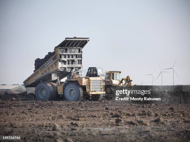 coal trucks reinstating the land at an opencast coal mine - coal wind stockfoto's en -beelden