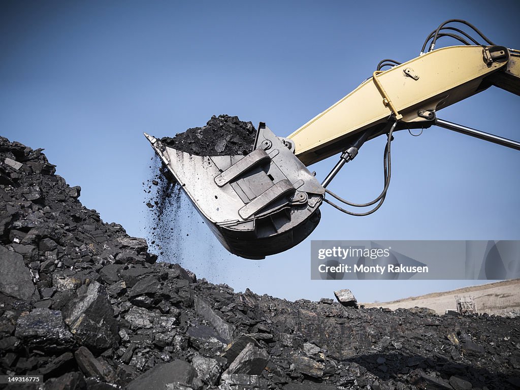 Digger lifting coal from opencast coalmine