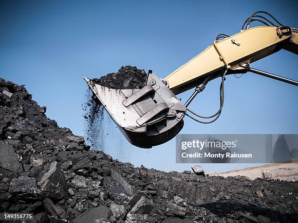 digger lifting coal from opencast coalmine - mining low angle foto e immagini stock