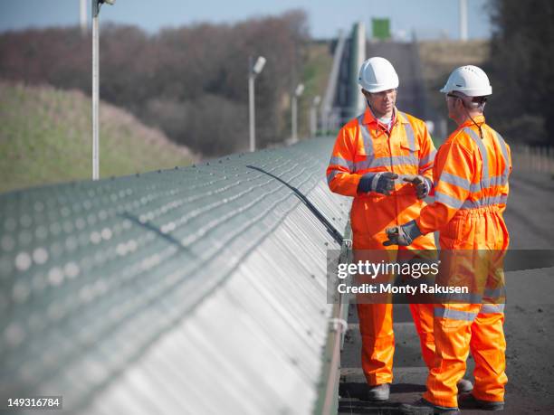 coalminers in discussion next to conveyor in opencast coalmine - macacão vestuário para proteção imagens e fotografias de stock