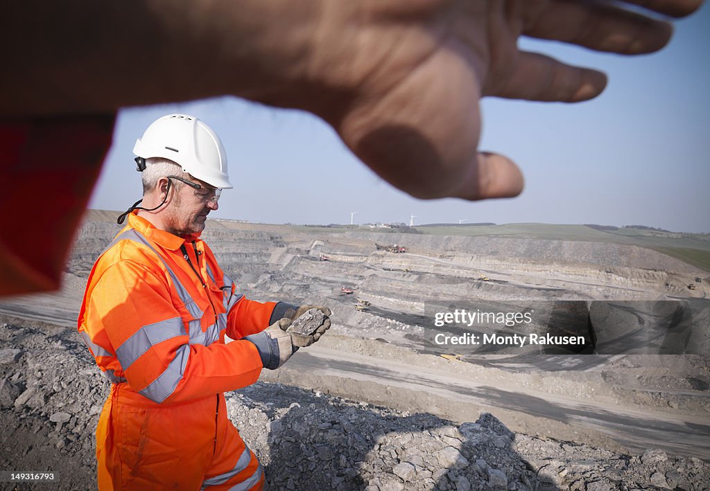 Geologist inspecting rock in opencast coalmine