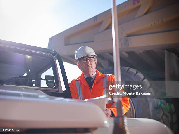 site manager holding plans in opencast coalmine - mining low angle foto e immagini stock