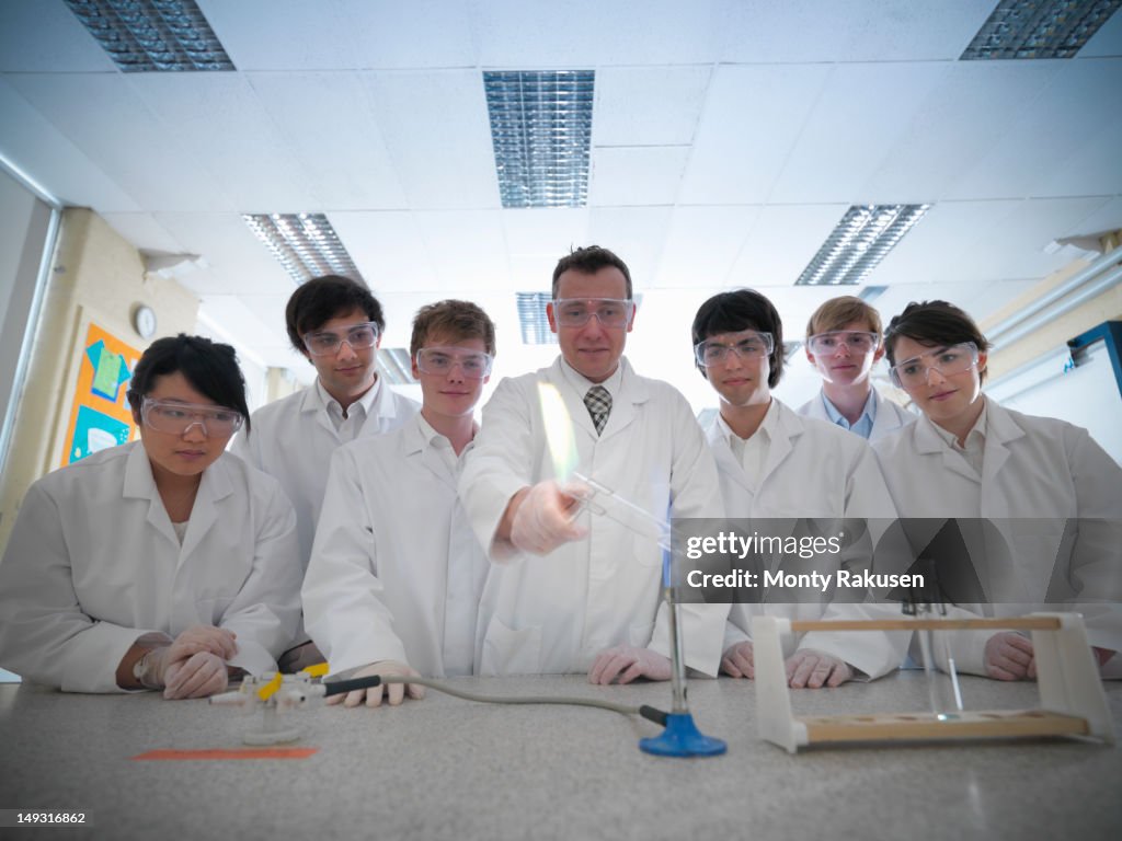 Science Teacher And Students Conducting Experiment In School Laboratory ...