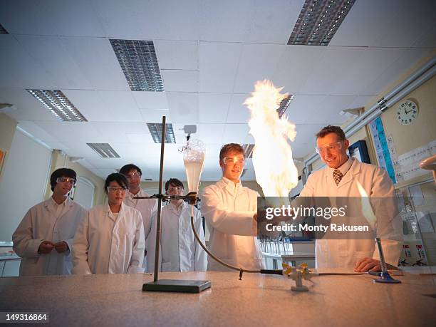 science teacher and students conducting experiment in school laboratory - bunsen burner stock pictures, royalty-free photos & images