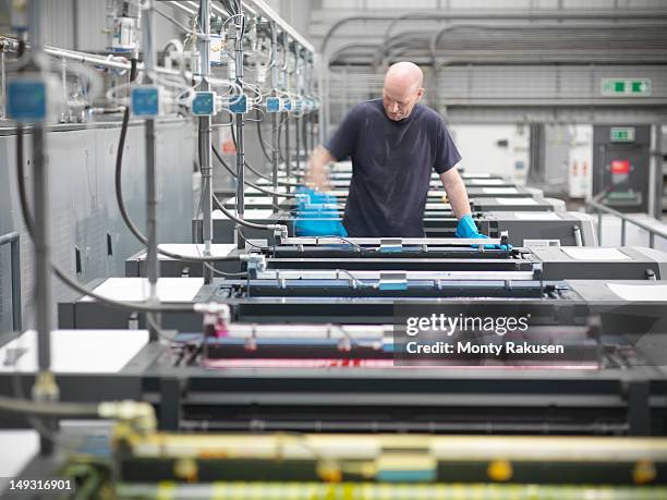 portrait of printworker loading ink into press in printworks - northants stock pictures, royalty-free photos & images
