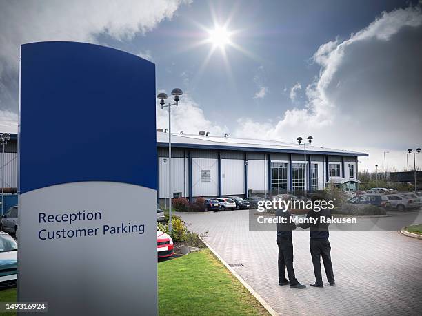 workers looking at the solar panels installed onto the roof of a factory building - kettering stock pictures, royalty-free photos & images