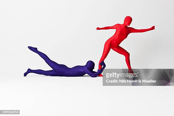 couple in bodysuits posing together - woman holding legs fotografías e imágenes de stock