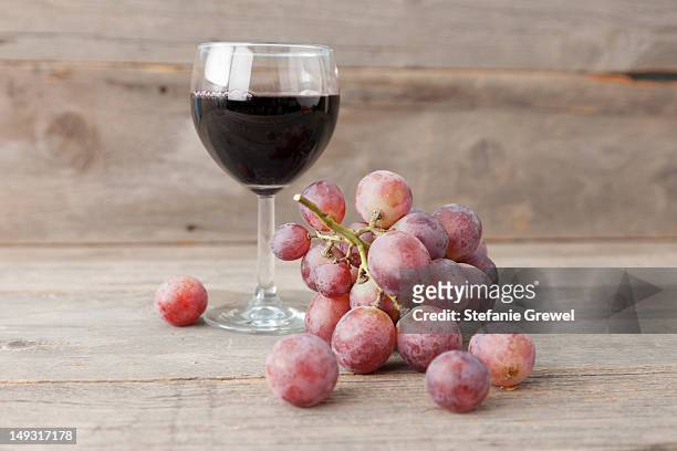 close up of grapes and glass of wine - bund stock-fotos und bilder