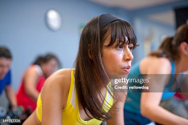 people using spin machines in gym - spin class stock pictures, royalty-free photos & images