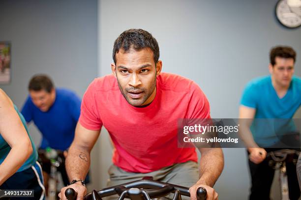 people using spin machines in gym - gym interior stock pictures, royalty-free photos & images