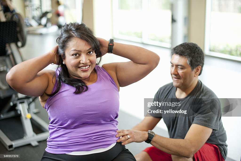 Woman working with trainer in gym