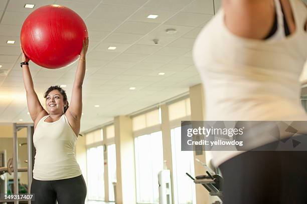 woman using exercise ball in gym - fitness ball imagens e fotografias de stock