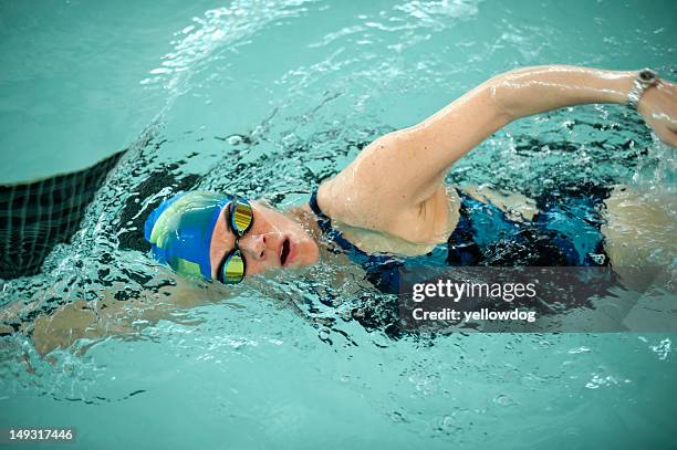 woman doing laps in swimming pool - mature women swimming stock pictures, royalty-free photos & images