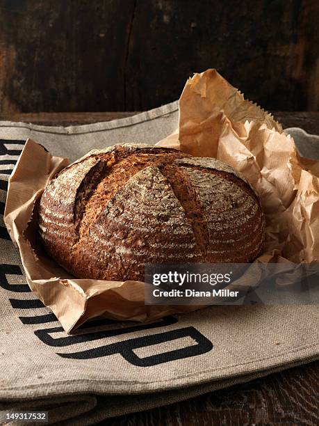 fresh baked bread in paper - rye bread stock pictures, royalty-free photos & images