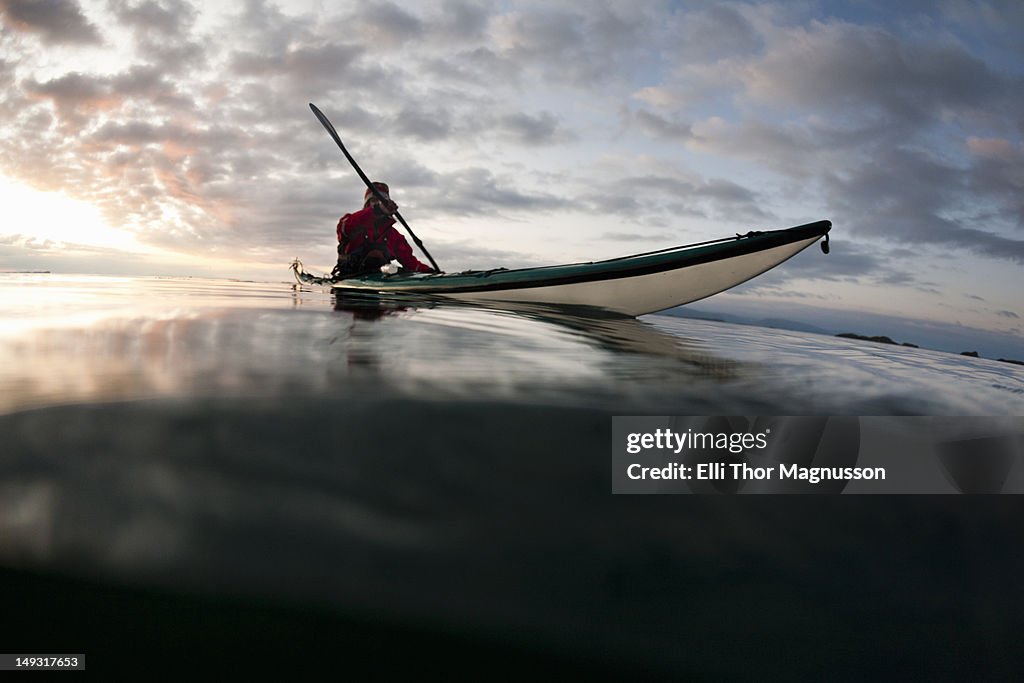 Man kayaking on still lake