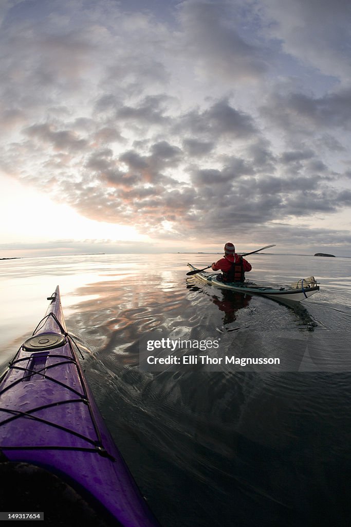 People kayaking on still lake