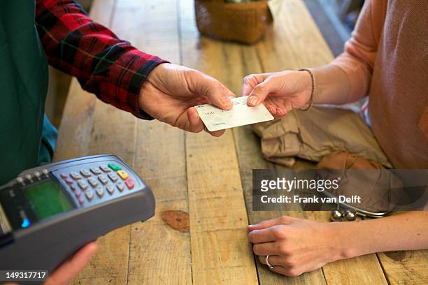 woman shopping with credit card in store - debit cards credit cards accepted stock pictures, royalty-free photos & images