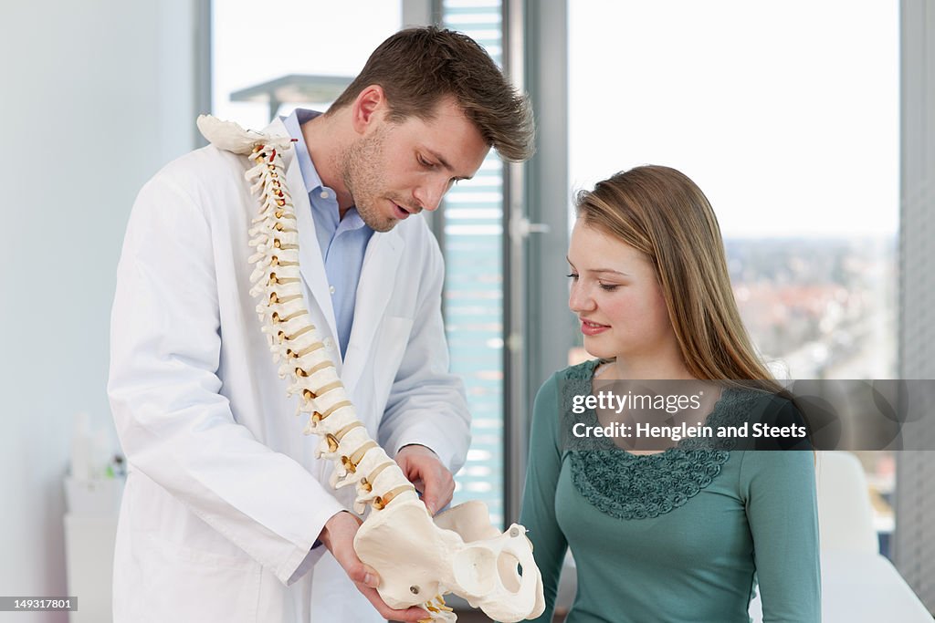 Doctor showing spine model to patient