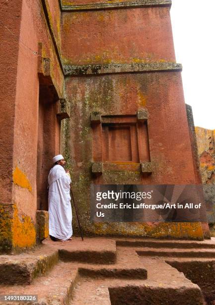 Ethiopian orthodox priest in front of a rock-hewn church, Amhara Region, Lalibela, Ethiopia on May 1, 2023 in Lalibela, Ethiopia.