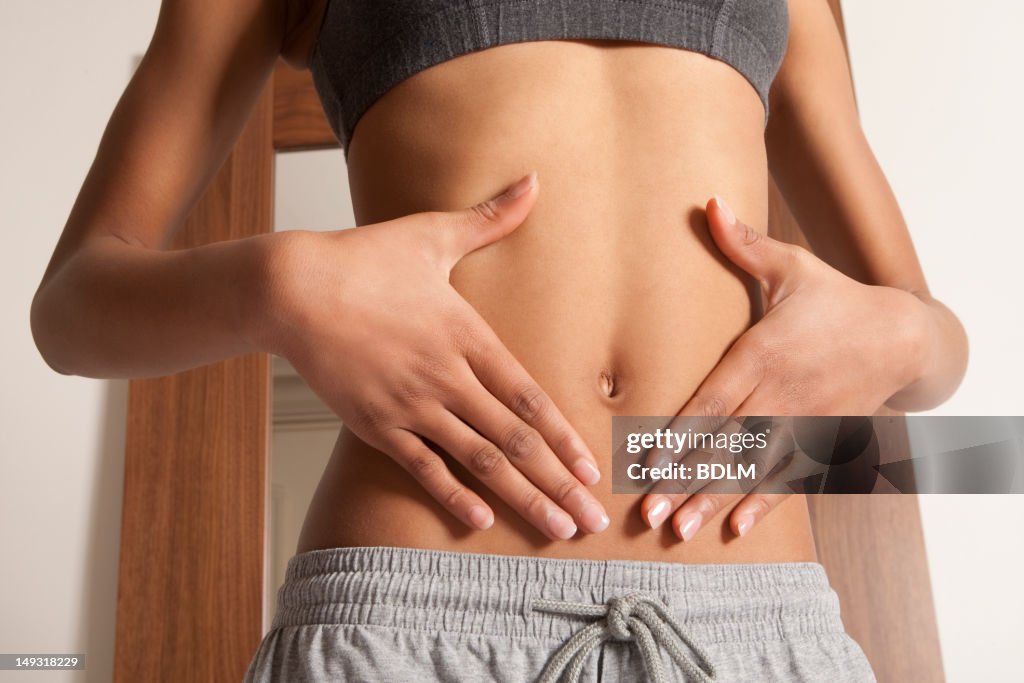 Womans hands cupping her bellybutton
