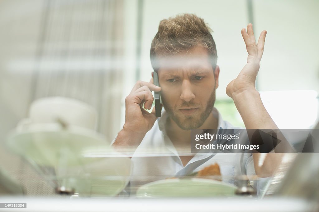 Man talking on cell phone at breakfast